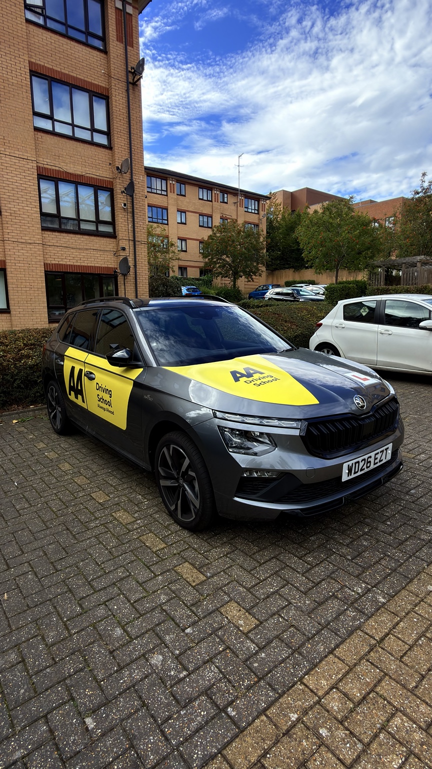 Cristian beside his current automatic Skoda tuition vehicle